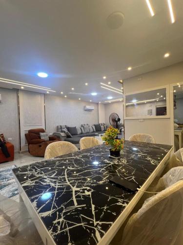 a dining room with a black marble table and chairs at Pearl pyramids Suites in Ghaţāţī
