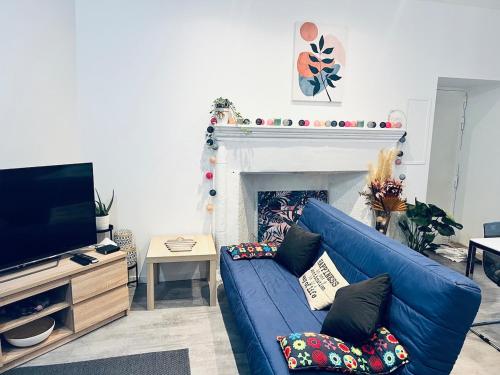 a living room with a blue couch and a fireplace at Studio Riom de Coeur in Riom