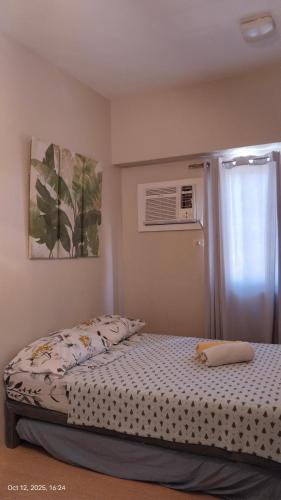 1 Schlafzimmer mit einem Bett und einem Fenster mit Klimaanlage in der Unterkunft Sunvida Cebu in Cebu City