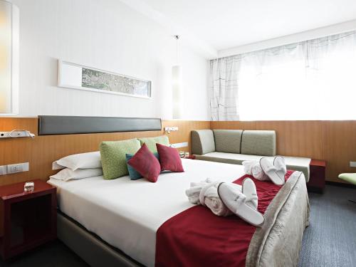 a hotel room with two beds with towels on them at Novotel Roma Eur in Rome