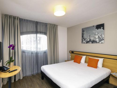 a hotel room with a bed and a window at Aparthotel Adagio Access Nancy Centre in Nancy