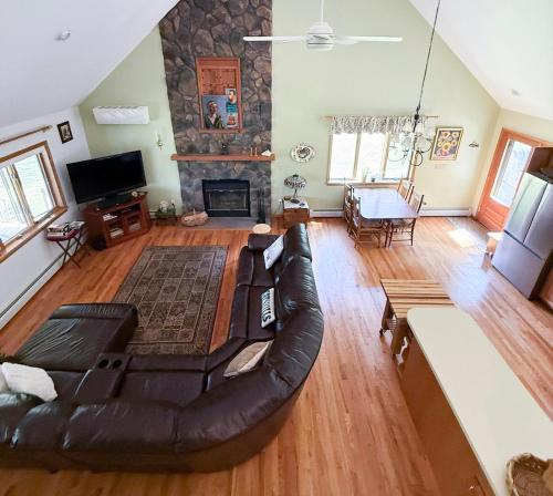 a living room with a leather couch and a fireplace at Mountain Retreat in the Catskills in Roxbury