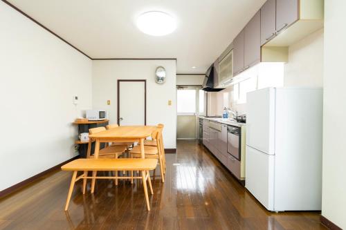 a kitchen with a table and chairs and a refrigerator at BUSON A cozy Japanese House upto 8 Guests and Close to Station in Osaka