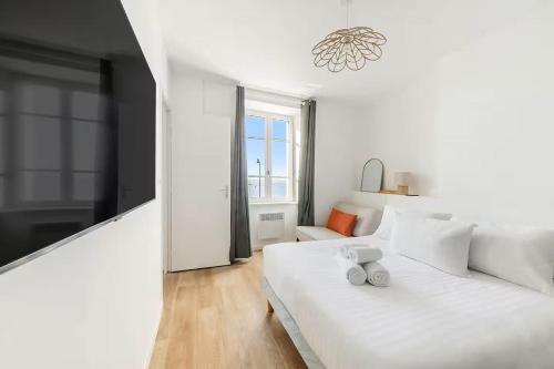 a white bedroom with a white bed and a window at Bord de l'Eau 4 in Cancale