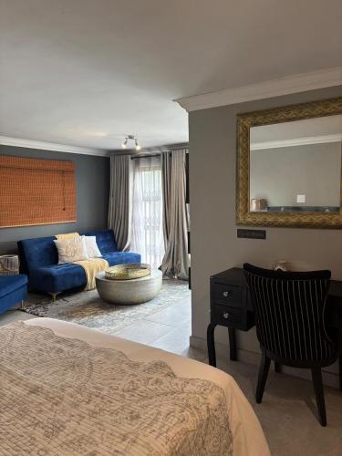 ein Schlafzimmer mit einem blauen Bett und einem blauen Sofa in der Unterkunft The Throne in Johannesburg
