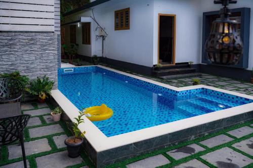 a swimming pool with a yellow float in the middle at The Kalt Private Pool Homestay Munnar in Anachal