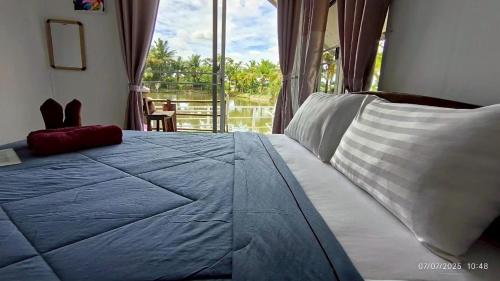 a bedroom with a bed with a large window at The forest hill cafe&homestays Chiangmai in Ban Muang Len