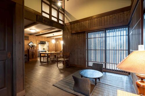 a room with a table and chairs in a room with a window at yado suzuka 1 in Suzuka