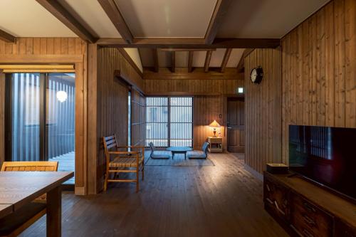a living room with wood paneled walls and a television at yado suzuka 1 in Suzuka
