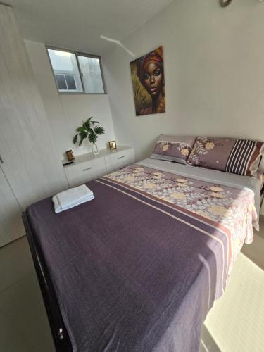 a bedroom with a large bed and a painting on the wall at Espectacular Apto de 3 Habitaciones con piscina y parqueadero gratuito excelente relacion calidad precio in Girardot