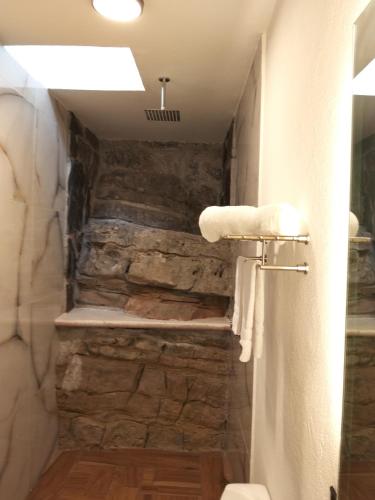 a bathroom with a stone wall and towels at Cabañas El Amanecer in Cuetzalán del Progreso