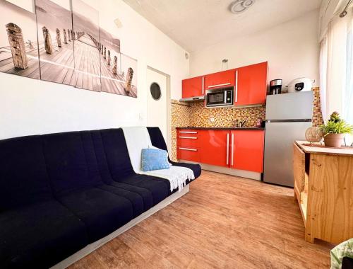 ラ・グランド・モットにあるAppartement tout équipé, à deux pas de la plageのソファとキッチンのあるリビングルーム
