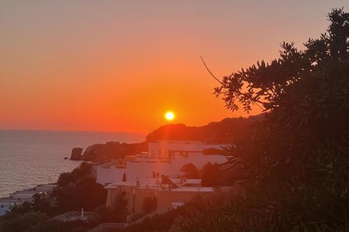 a sunset over a small town on the ocean at Villa Palma - Sunset Sea Views with Pool, Jacuzzi, Sauna and Games Room in Mellieħa