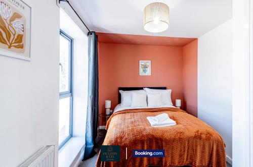 a small bedroom with orange walls and a bed at Luxury Retreat For 10 - Short Lets & Serviced Accommodation Manchester With Hot Tub and Spacious Garden in Manchester