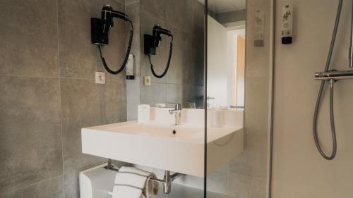 ein Badezimmer mit Waschbecken und Dusche in der Unterkunft Floreal Le Panoramique in Mont-Saint-Aubert