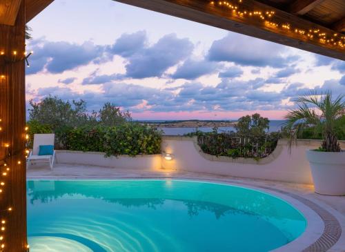 a swimming pool in a villa with a view of the ocean at Villa Alexandra: Sea Views Pool Jacuzzi Sauna in Mellieħa