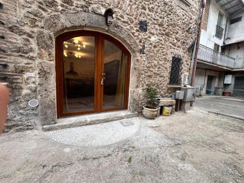 a stone building with a glass door on a street at iL CASALE DI ROCCO in Castel SantʼAngelo