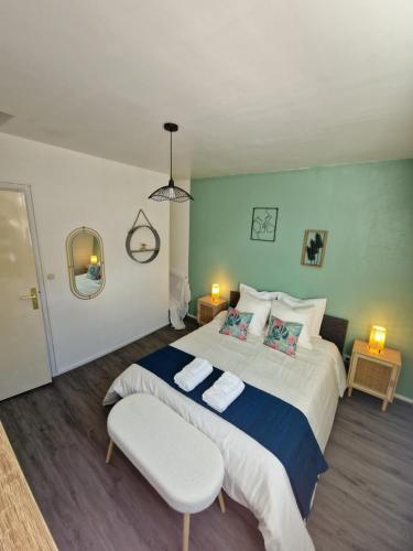 a bedroom with a large bed and a chair at La Belle Armentières, maison triplex cosy proche de Lille in Armentières