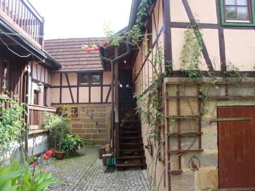 an old house with a staircase in a courtyard at Ferienwohnung Koppelblick in Pfarrweisach