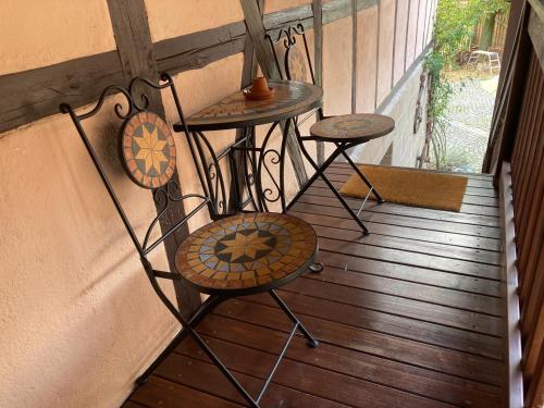 a balcony with two tables and two chairs on a porch at Ferienwohnung Koppelblick in Pfarrweisach