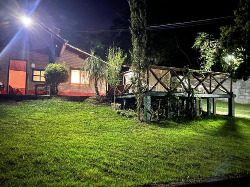 a backyard at night with a tree and a house at Chácara Pedacinho do Céu in Extrema