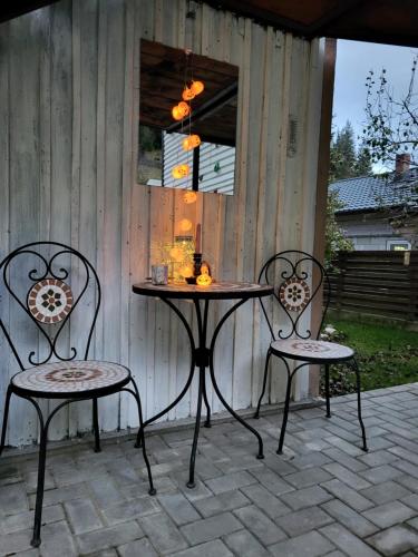 Una mesa y dos sillas en un patio. en Căsuța Piticilor, en Broşteni