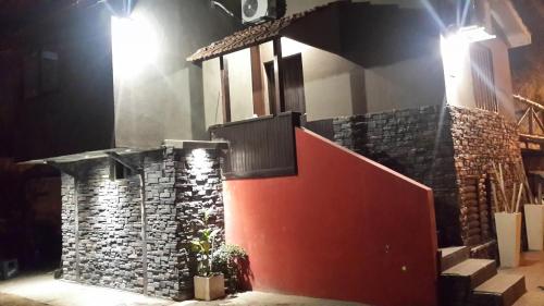 un edificio con una pared de piedra y escaleras por la noche en UNICA Casa Centro frente al lago, pileta climatizada, 4 dorm, 3 baños, 3 autos, aire, en Villa Carlos Paz
