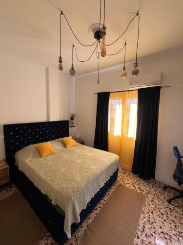 un dormitorio con una cama y una ventana en AA seaside apartment, en Artemida