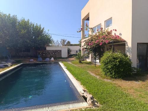 a swimming pool in a yard next to a house at dareddroudj in Staoueli