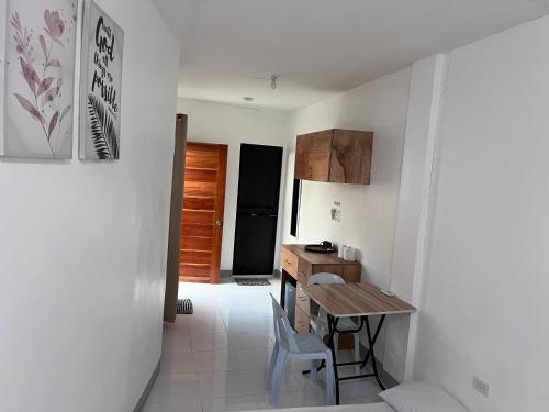 a small kitchen with a table and a small desk at GJE's LODGE AND GUEST HOUSE in Moalboal