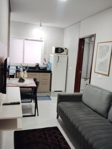 a living room with a couch and a kitchen at Apartamento 520C in Maringá