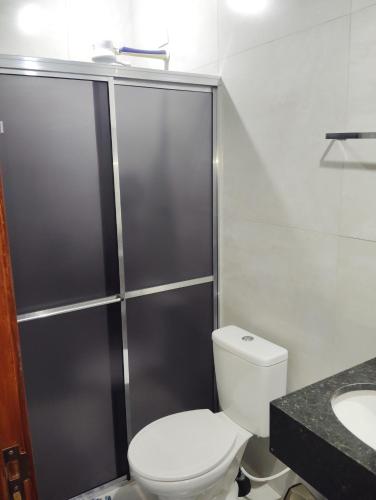 a bathroom with a toilet and a shower and a sink at Apartamento 520C in Maringá
