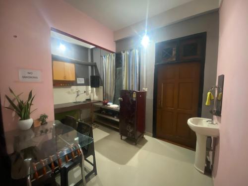 a bathroom with a sink and a wooden door at Haven Stay in Dibrugarh