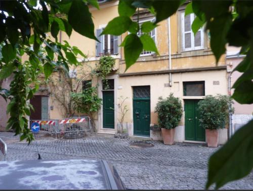 a building with green doors and plants on a street at Comfy in the Heart of Roman nightlife in Rome
