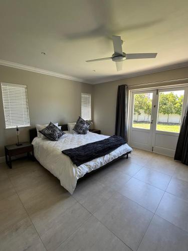 a bedroom with a bed and a ceiling fan at 1 Diadem in Plettenberg Bay