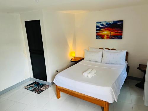 a bedroom with a large white bed in a room at GJES Lodge AND GUESTHOUSE in Moalboal