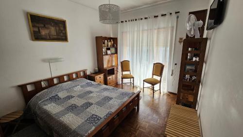 ein Schlafzimmer mit einem Bett und Stühlen in der Unterkunft Suite Porto in Porto