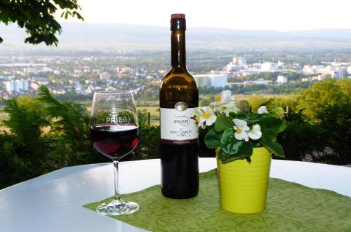 una bottiglia di vino e un bicchiere su un tavolo di Pension Forstgut Waldeck a Ingelheim am Rhein
