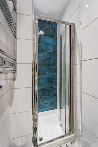 a shower with a mirror in a bathroom at The Adelphi Aparthotel in Stratford-upon-Avon