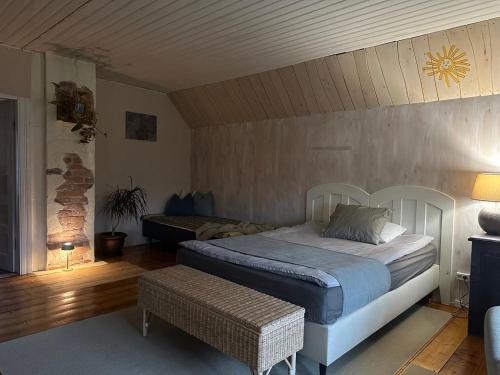 1 dormitorio con cama y banco. en Maal ja Veel, en Misso