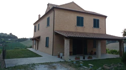 a large brick building with blue shutters on it at Ross House in Fermo