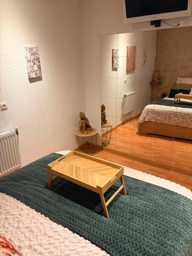 a living room with a coffee table and a bed at Chez SOPHIE, logement avec jacuzzi et salle cinéma in Altviller