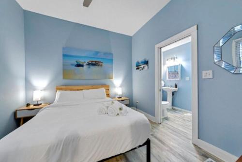 a blue bedroom with a large bed and a bathroom at Short North - Convention - Queen Bed -Free Parking in Columbus