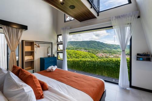 a bedroom with a bed and a large window at Villa Bosque CR in Turrialba