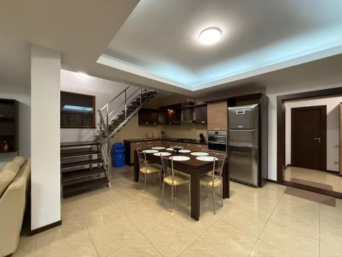 eine Küche und ein Esszimmer mit einem Tisch und einem Kühlschrank in der Unterkunft AMK House - Busteni in Buşteni