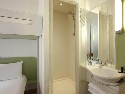 a bathroom with a sink and a shower and a toilet at ibis budget Tours Nord in Tours