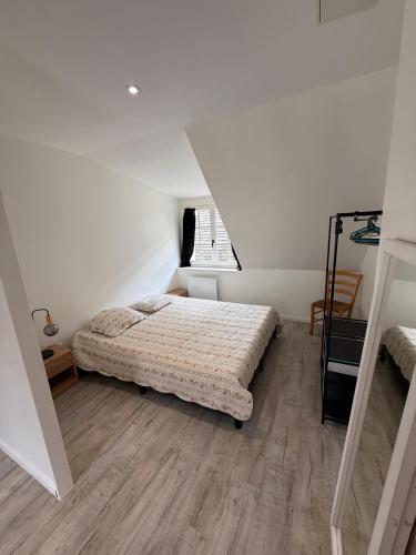 un dormitorio con una cama y una ventana en Sous les Toits de Boussac, en Boussac