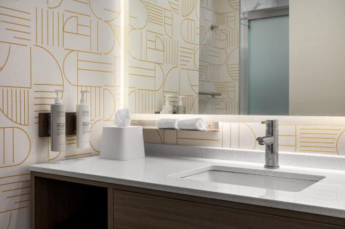 a bathroom with a sink and a mirror at Home2 Suites By Hilton Woodstock On in Woodstock