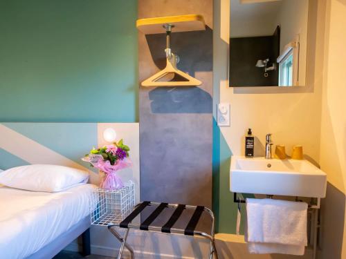 アグノーにあるibis budget Haguenau Strasbourg Nordのシンクとベッドが備わる小さな客室です。