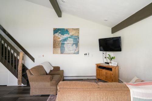 ゲイロードにあるQuiet and Cozy Lakefront Home Near Mt Boyneのソファとテレビのあるリビングルーム